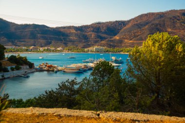 ICMELER, MUGLA, TURKEY: Güneşli bir yaz günü, Türkiye 'de Marmaris yakınlarında kıyı manzaralı ve Icmeler' de gemiler olan güzel manzara.