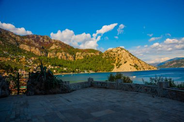Türkiye 'nin Marmaris yakınlarındaki Mugla ilinde güneşli bir yaz gününde Turunc köyünün dağ ve deniz manzarası.