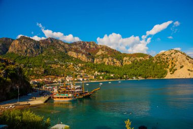 Türkiye 'nin Marmaris kenti yakınlarındaki Mugla ilinde güneşli bir yaz gününde Turunch sahilindeki korsan gemisi ve teknelerinin en iyi görüntüsü.