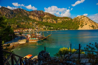 Türkiye 'nin Marmaris kenti yakınlarındaki Mugla ilinde güneşli bir yaz gününde Turunch sahilindeki korsan gemisi ve teknelerinin en iyi görüntüsü.