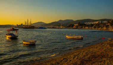 Akşam Bodrum 'da gün batımında gemi ve tekne manzaralı güzel bir romantik deniz manzarası.