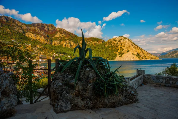 Türkiye 'nin Marmaris yakınlarındaki Mugla ilinde güneşli bir yaz gününde Turunc köyünün dağ ve deniz manzarası.