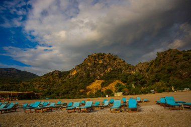 OLUDENIZ, FETHIYE, TURKEY: bulutlu Oludeniz plajında Sun Loungers ile güzel manzara. Oludeniz plajı Türkiye 'nin en iyi plajları.