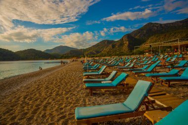 OLUDENIZ, FETHIYE, TURKEY: bulutlu Oludeniz plajında Sun Loungers ile güzel manzara. Oludeniz plajı Türkiye 'nin en iyi plajları.