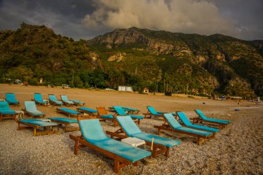 OLUDENIZ, FETHIYE, TURKEY: bulutlu Oludeniz plajında Sun Loungers ile güzel manzara. Oludeniz plajı Türkiye 'nin en iyi plajları.