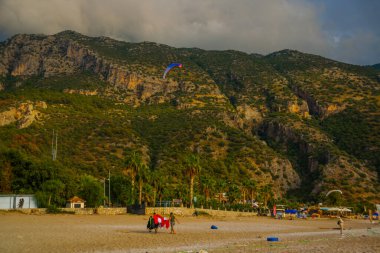 OLUDENIZ, FETHIYE, TURKEY: Bulutlu bir günde Oludeniz plajı ve dağlar manzaralı manzara. Oludeniz plajı Türkiye 'nin en iyi plajları.
