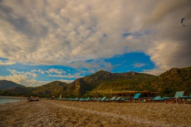 OLUDENIZ, FETHIYE, TURKEY: bulutlu Oludeniz plajında Sun Loungers ile güzel manzara. Oludeniz plajı Türkiye 'nin en iyi plajları.