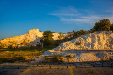 PAMUKALE, DENIZLI, TURKEY: Pamukkale 'de güneşli bir sabahta beyaz travertin manzaralı manzara.