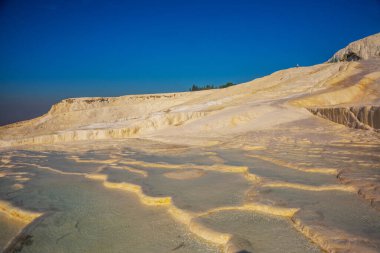 PAMUKALE, DENIZLI, TURKEY: Beyaz travertinlerde güzel karmaşık doğal desen. Türkiye 'nin en ünlü eğlencelerinden biri olan Pamukkale, bir Unesco Dünya Mirası sahası..