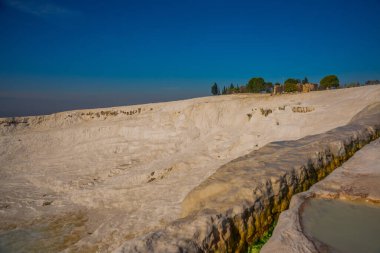PAMUKALE, DENIZLI, TURKEY: Pamukkale 'de güneşli bir günde beyaz trenler üzerinde doğal su akıntısı.