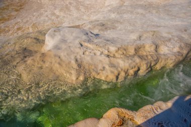 PAMUKALE, DENIZLI, TURKEY: Pamukkale 'de güneşli bir günde beyaz trenler üzerinde doğal su akıntısı.