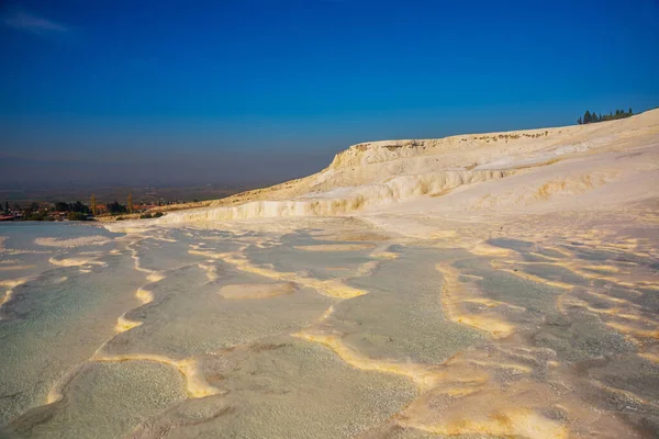 PAMUKALE, DENIZLI, TURKEY: Güneşli bir günde güzel beyaz travertin terasları. Türkiye 'nin en ünlü eğlencelerinden biri olan Pamukkale, bir Unesco Dünya Mirası sahası..