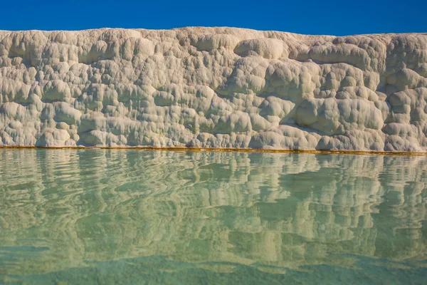 Stock image PAMUKKALE, DENIZLI, TURKEY: White travertines and a pool with clear water in Pamukkale on a sunny day.