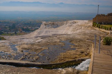 PAMUKALE, DENIZLI, TURKEY: Pamukkale 'de güneşli bir günde beyaz travertin manzaralı manzara.
