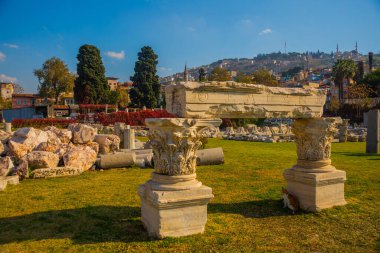 İzmir 'de güneşli bir günde antik Agora kalıntıları, eski kasaba ve kale manzarası.