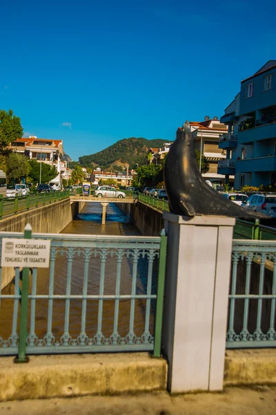 Marmaris, MUGLA, TURKEY: Şehir merkezinde bir kanal ve güneşli bir günde Marmaris 'te bir fokun heykeli.