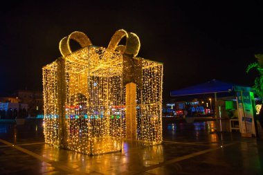 Marmaris, MUGLA, TURKEY: güzel büyük dekoratif bir kutu hediye sarı çelenkler gece Marmaris meydanının ortasında.