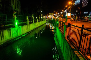 MARMARIS, MUGLA, TURKEY: Şehir görünümü kanal ve çeşme ile gece balık heykelleri ile modern ticaret merkezi arka planda