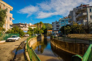 Güneşli bir günde, Marmaris şehrinin sokaklarında suyla dolu bir kanal..