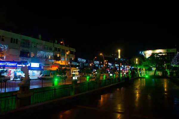 MARMARÍS, TURQUÍA: Vista de la ciudad para canalizar y fuente con esculturas de peces por la noche. — Foto de Stock