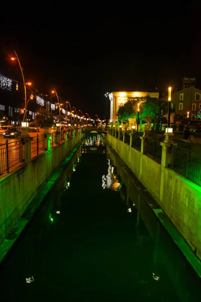 MARIS, TURKEY: Stadsutsikt över kanal och fontän med skulpturer av fisk på natten. — Stockfoto