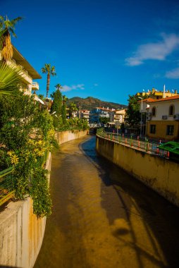 Marmaris, MUGLA, TURKEY: Güneşli bir günde Marmaris şehrinin caddesinde suyla dolu bir kanal.