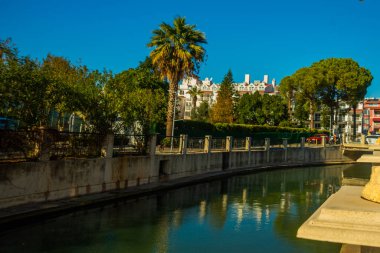 Marmaris, MUGLA, TURKEY: Güneşli bir günde Marmaris şehrinin caddesinde suyla dolu bir kanal.