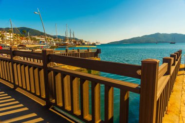 Marmaris, MUGLA, TURKEY: Güneşli bir günde Marmaris 'te deniz kenarındaki gezinti güvertesinde kanal ve ahşap köprü.