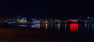 Marmaris, MUGLA, TURKEY - Geceleri Marmaris manzarası. Siyah gökyüzü ve denizin arka planında çok renkli ışıklar.