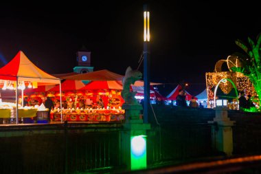 MARMARIS, MUGLA, TURKEY: View of the Canal with Fish sculptures and the New Year's fair at night in Marmaris.