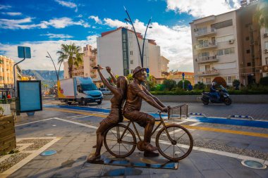 MARMARIS, MUGLA, TURKEY: A modern monument of a guy and a girl riding a bicycle on the street in Marmaris.