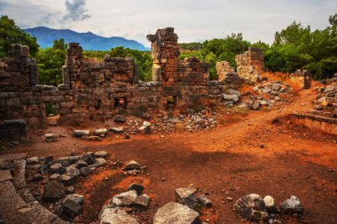 PHASELIS, KEMER, TURKEY: Ruins of the amphitheatre of the ancient city of Phaselis on mountains and clouds background in Turkey, village Tekirova, Antalya province, near Kemer.