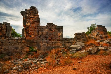 PHASELIS, KEMER, TURKEY: Ruins of the amphitheatre of the ancient city of Phaselis on mountains and clouds background in Turkey, village Tekirova, Antalya province, near Kemer.