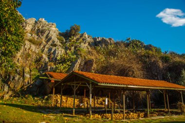 Iuilik Arkeoloji Parkı ya da Refah Kayaları, güneşli bir günde mavi bir arka planda, Marmaris 'in merkezindeki bir yamaçta bulunan eşsiz bir açık hava müzesidir..