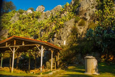 Iuilik Arkeoloji Parkı ya da Refah Kayaları, güneşli bir günde mavi bir arka planda, Marmaris 'in merkezindeki bir yamaçta bulunan eşsiz bir açık hava müzesidir..