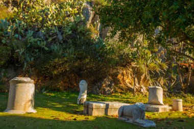 Iuilik Arkeoloji Parkı ya da Refah Kayaları, güneşli bir günde mavi bir arka planda, Marmaris 'in merkezindeki bir yamaçta bulunan eşsiz bir açık hava müzesidir..