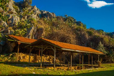 Iuilik Arkeoloji Parkı ya da Refah Kayaları, güneşli bir günde mavi bir arka planda, Marmaris 'in merkezindeki bir yamaçta bulunan eşsiz bir açık hava müzesidir..
