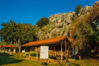 Iuilik Arkeoloji Parkı ya da Refah Kayaları, güneşli bir günde mavi bir arka planda, Marmaris 'in merkezindeki bir yamaçta bulunan eşsiz bir açık hava müzesidir..