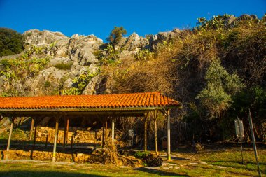 Iuilik Arkeoloji Parkı ya da Refah Kayaları, güneşli bir günde mavi bir arka planda, Marmaris 'in merkezindeki bir yamaçta bulunan eşsiz bir açık hava müzesidir..