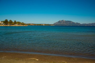 DATCA, MUGLA, TURKEY: Güneşli bir günde kumsaldan denize ve Datca kasabasındaki dağlardan güzel manzara.