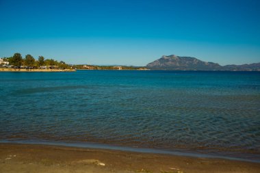 DATCA, MUGLA, TURKEY: Güneşli bir günde kumsaldan denize ve Datca kasabasındaki dağlardan güzel manzara.