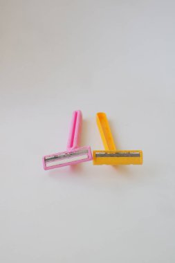 Beyaz izole arkaplan fotoğrafında pembe ve sarı sakal jileti kullanılmış.