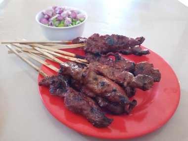 Kırmızı tabakta sığır eti satayı.