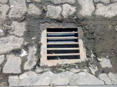 Demir rögar kapağı tuğla yol fotoğrafında.