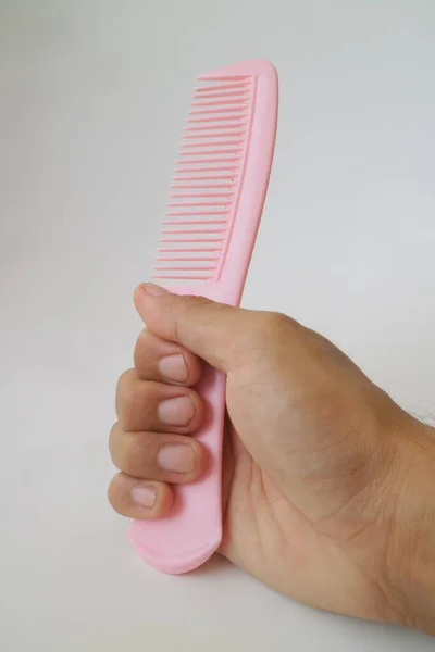 Hands Holding Pink Comb Photo — стоковое фото