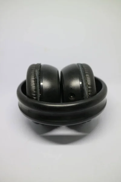 白い背景に黒いブルートゥルーのヘッドフォンが折り畳まれた写真 — ストック写真