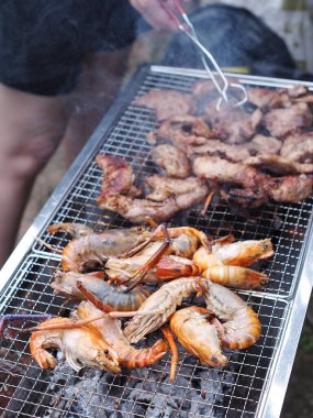Kömür ızgarasında taze ızgara karides, domuz eti ve tuzlu ve geleneksel soya kaynağıyla birlikte yaz partisinde kırsal alan otantik sobası..
