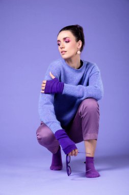 Mor menekşe rengi elbisesi olan güzel bir kızın portresi, mor menekşe üzerine izole edilmiş. Mor menekşe makyaj.