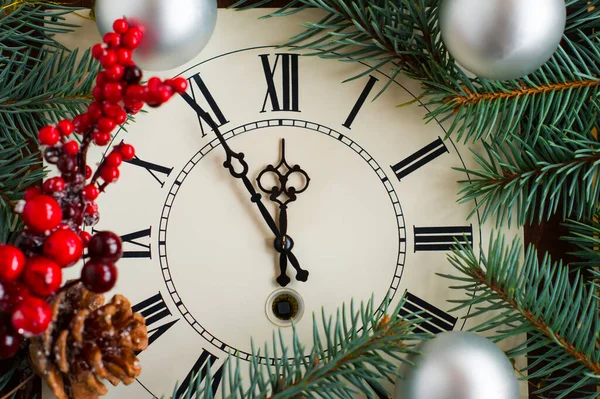 Christmas clock with silver balls, New Year\'s branch with red berries and cones. the concept of meeting the new year and Christmas