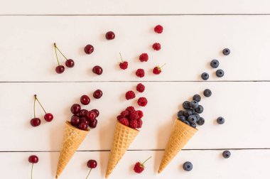 Beyaz ahşap bir masada meyveli gevrek waffle konileri. Tazeleyici tatlı